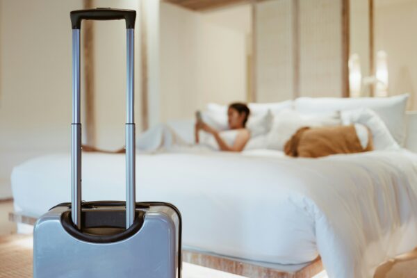 Khách đi du lịch nghỉ dưỡng tại khách sạn với suitcase trong phòng ngủ