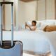 Khách đi du lịch nghỉ dưỡng tại khách sạn với suitcase trong phòng ngủ